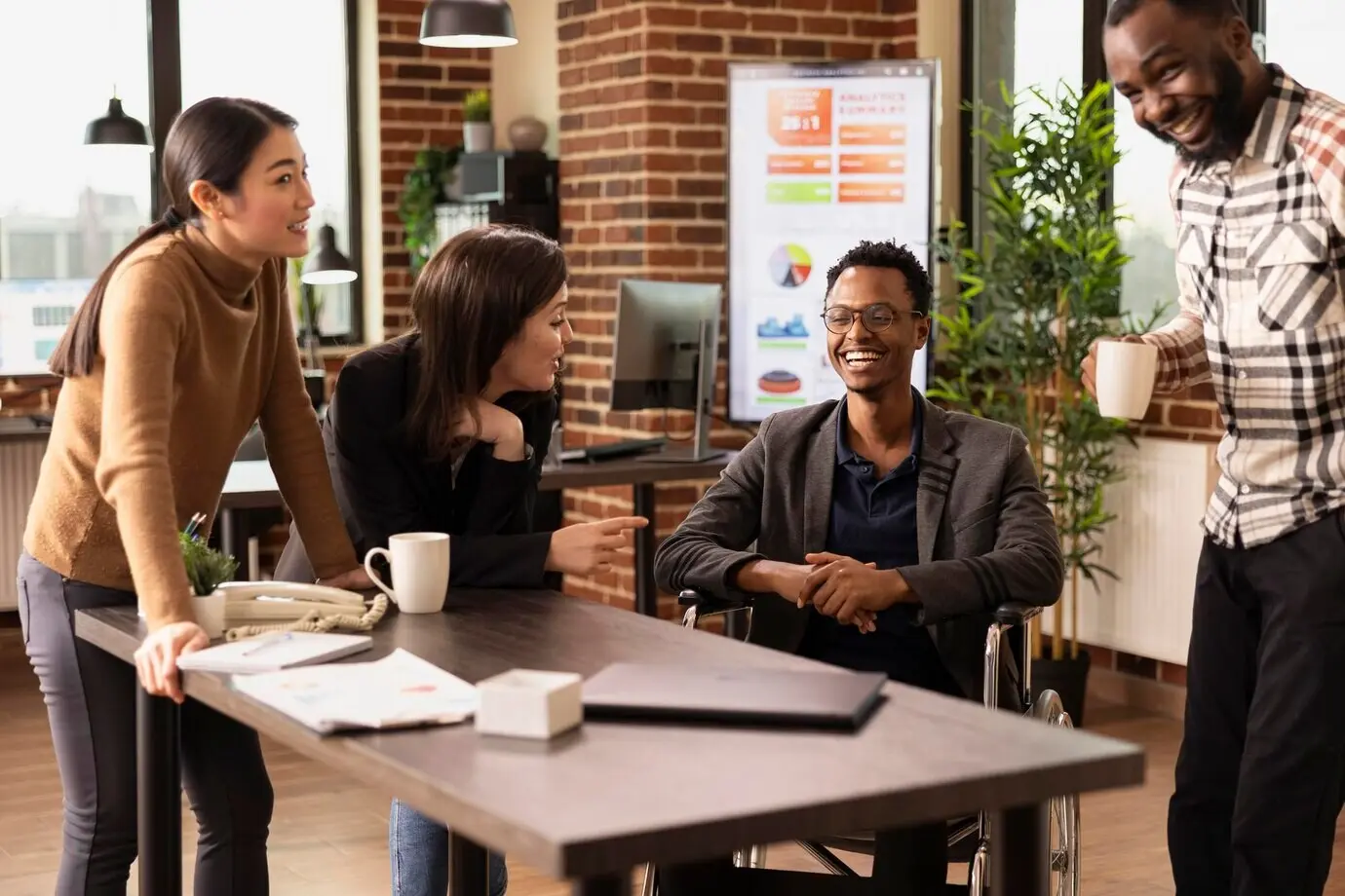 Мужчина с инвалидностью беседует с коллегами.