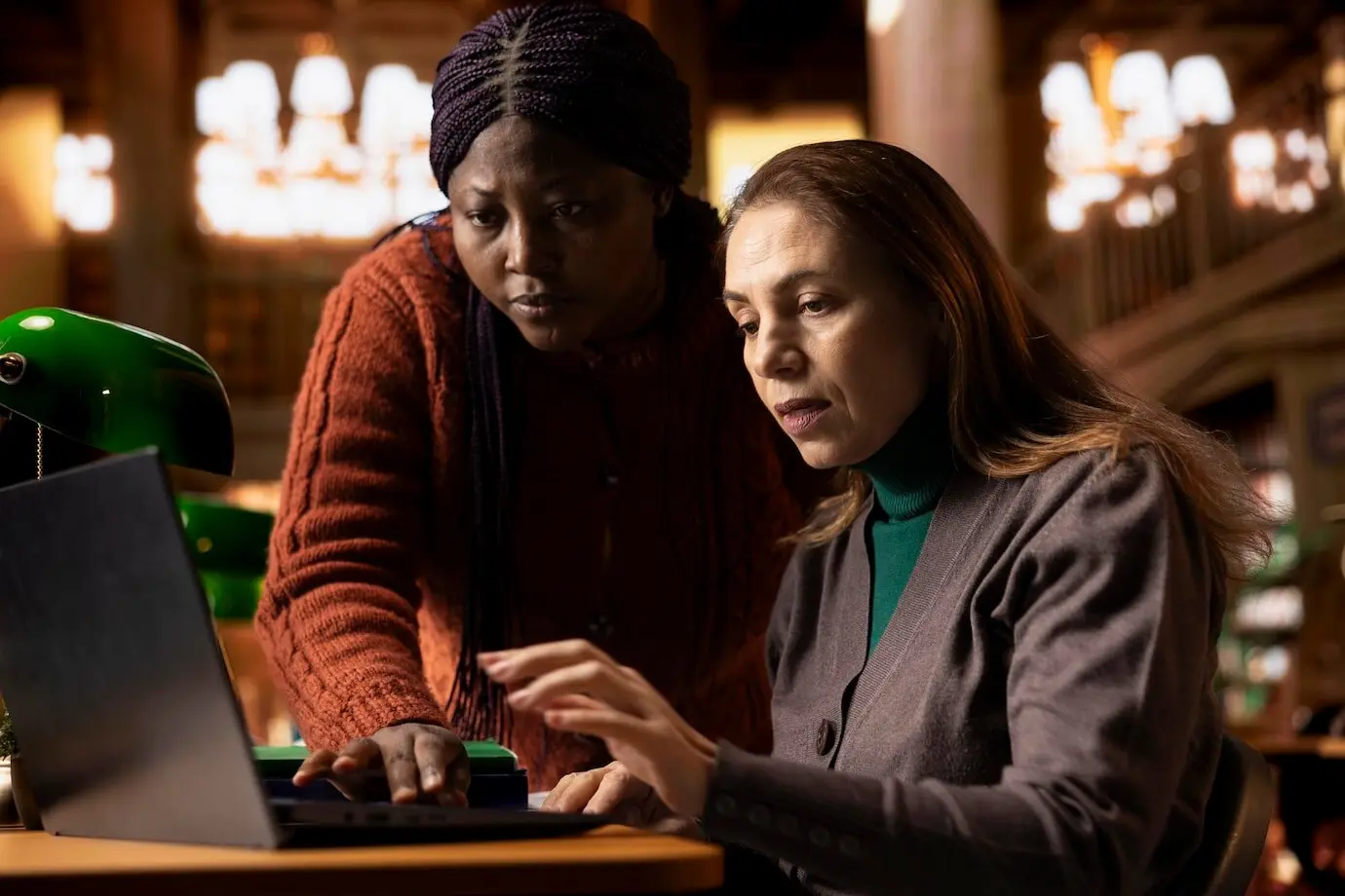 Команда разнообразных интеллектуальных пожилых женщин, читающих учебник онлайн.